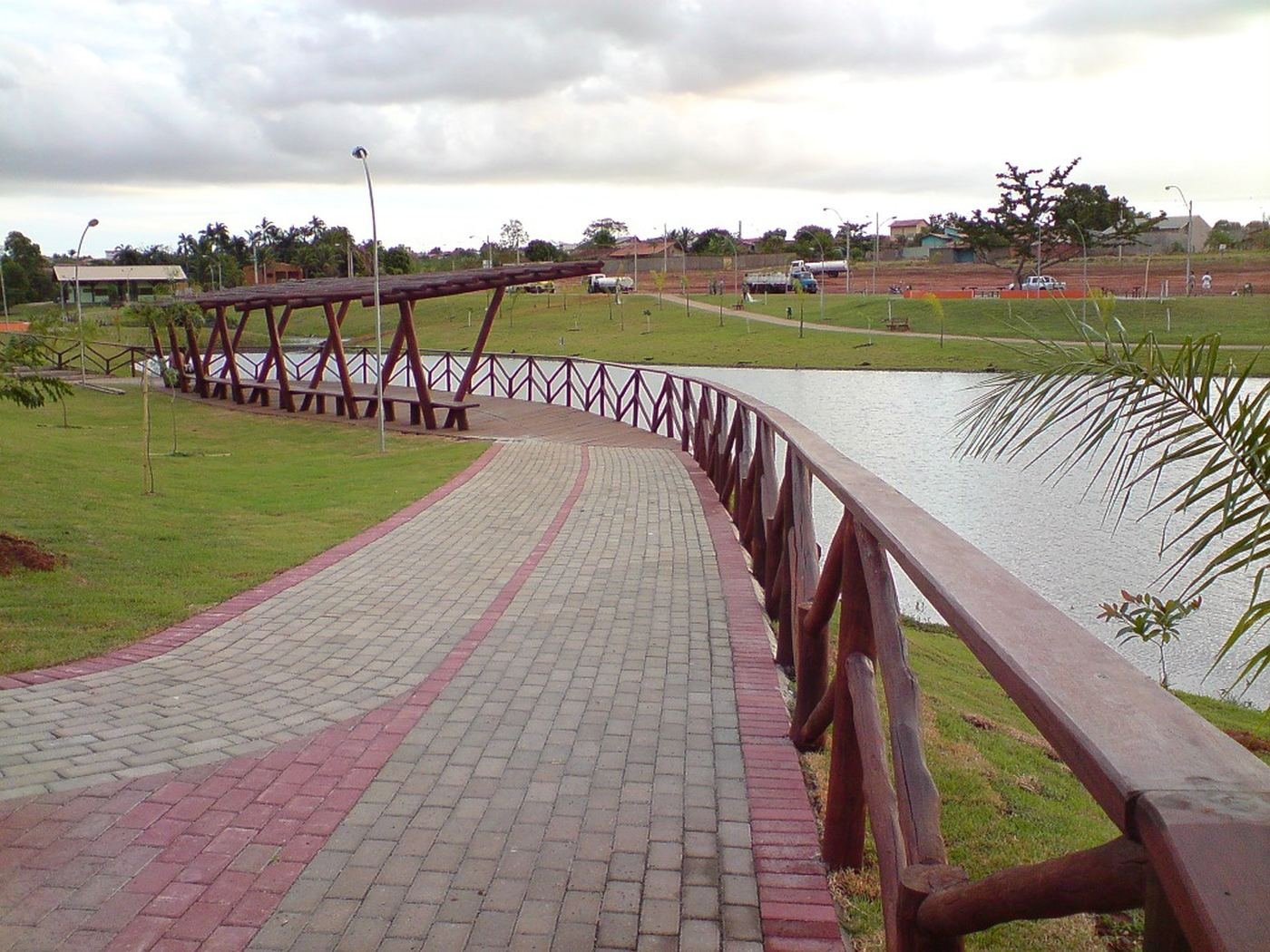Caminho de piso intertravado com guarda-corpo de madeira margeando o lago do Parque Cascavel